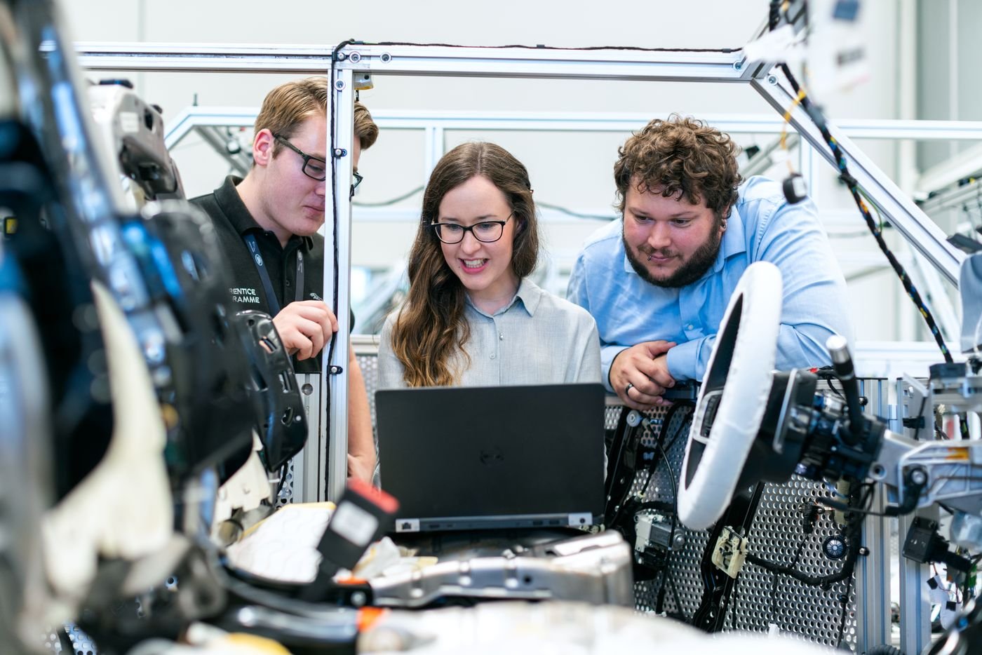 Technicians examining an engine bay together in a workshop