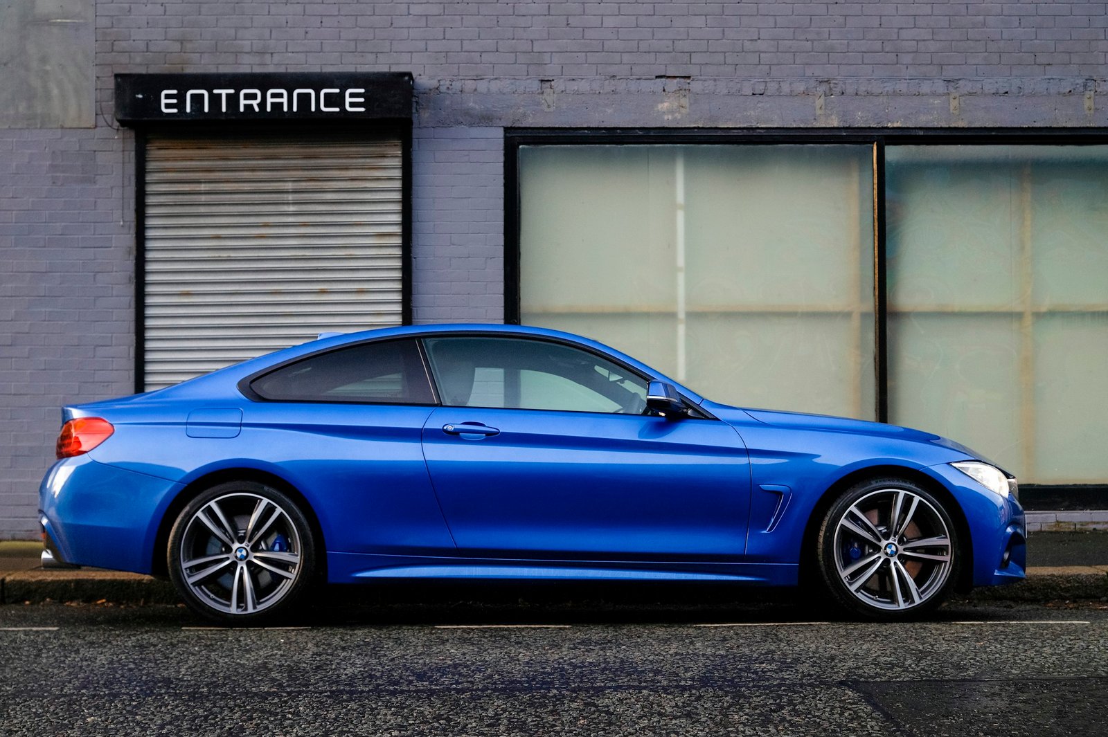 Car parked in front of a row of garage service doors