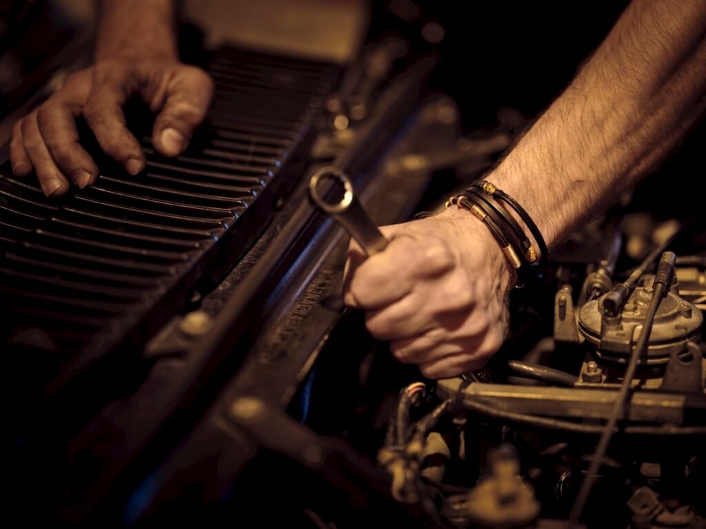 Close view of hands servicing a vehicle engine