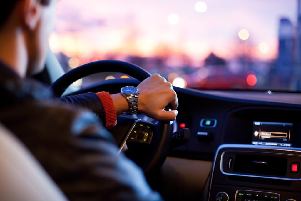 Driver hands resting on a vehicle steering wheel